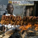A man arranges sticks of meat on a mud platform for roasting in the ancient city of Kano 19 April, 2007. Roasted meat on sticks popularly known as 'Suya' is a common delicacy in northern Nigeria. AFP PHOTO PIUS UTOMI EKPEI (Photo credit should read PIUS UTOMI EKPEI/AFP/Getty Images)